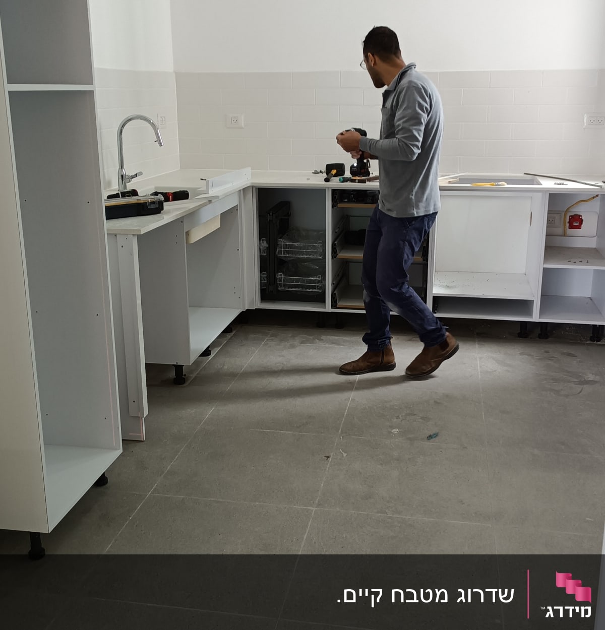 אדם מתקין ארונות מטבח עם כלים חשמליים